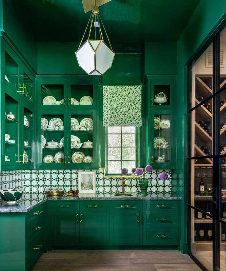 A butler's pantry color-drenched emerald green, including the cabinets and ceiling, in a high-gloss finish.