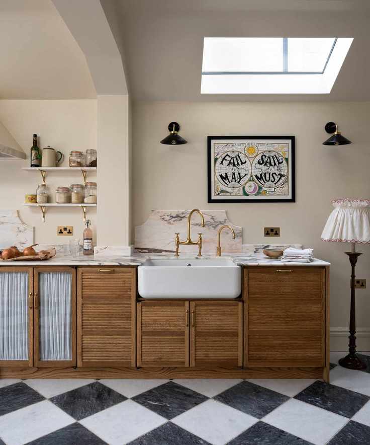 devol wooden kitchen cabinets with black and white checkerboard floor and a pink marble countertop and backsplash