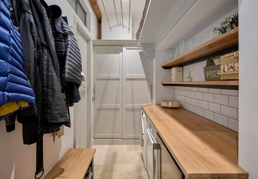 Utility room with wooden counters and shelving for added storage