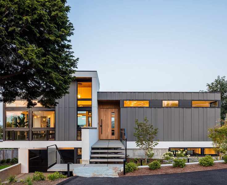 An example of front garden ideas showing a modern home with steps leading up to the front door