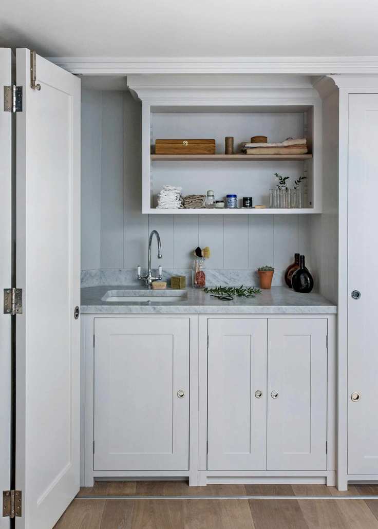 Laundry area separated by folding doors in a white design.