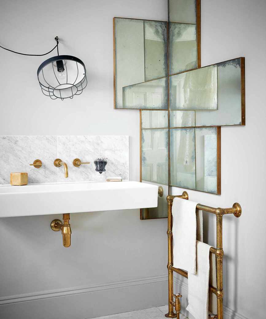 A sleek white bathroom with an interesting mirror