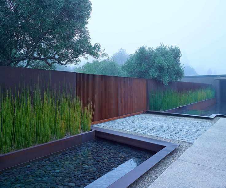 A modern front yard with metal gate designed by SurfaceDesign Inc