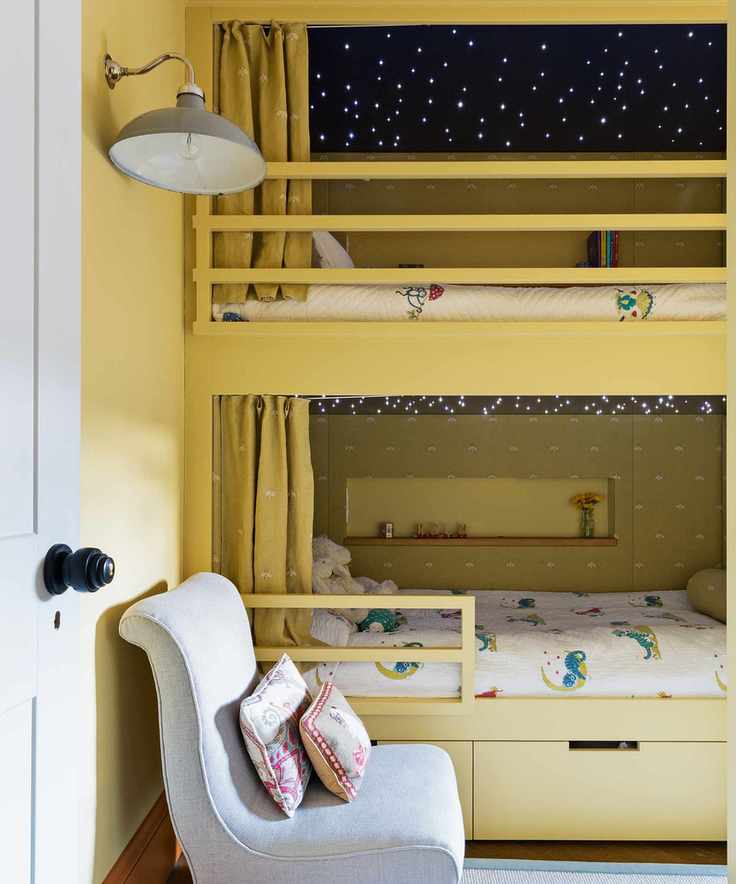 A yellow bunk bed adorned with fairy lights