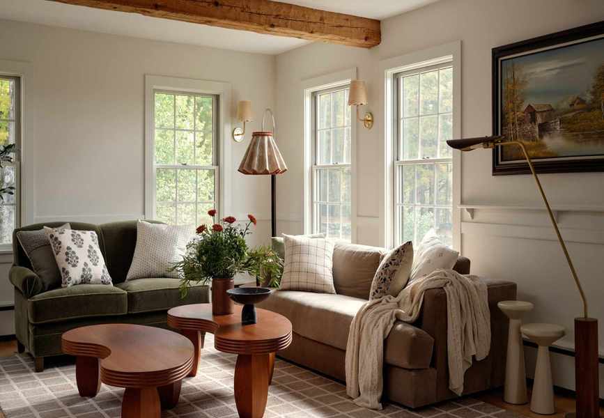 Neutral living room with ceiling beams, an olive green sofa and a warm wood coffee table, interior