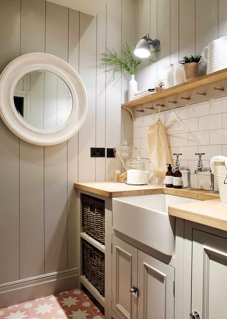 Pale gray laundry room with wooden elements and open shelving.