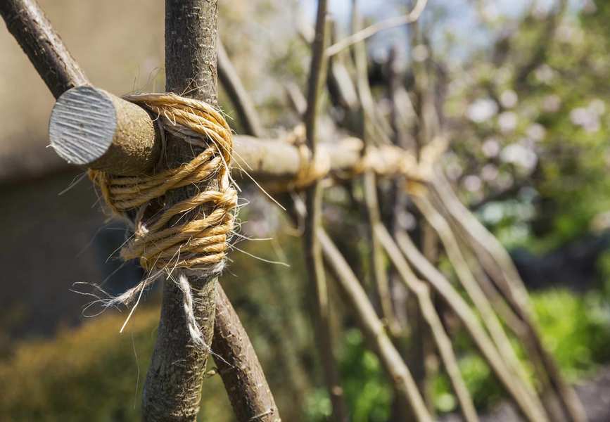 Close up of a handmade wooden trellis tied with twine in a garden