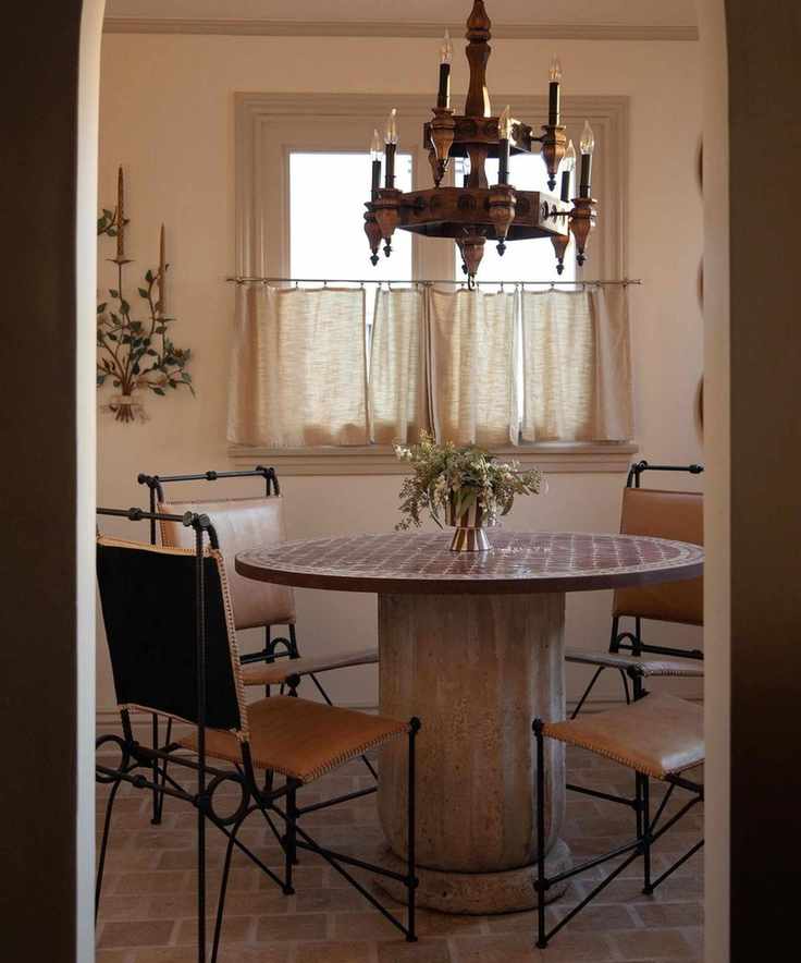 Breakfast nook with red terracotta floor tiles and antique dining chairs