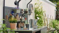 Stainless steel outdoor kitchen with pots and gardening tools