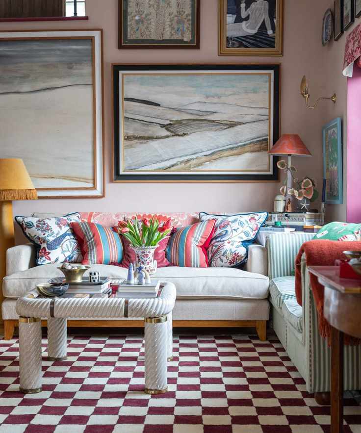 Cozy living room with off-white sofa, colorful cushions and artwork, red and white checkered carpet