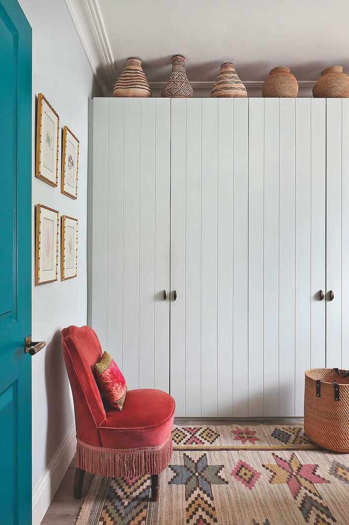 white painted bedroom closet with row of decorative baskets on top