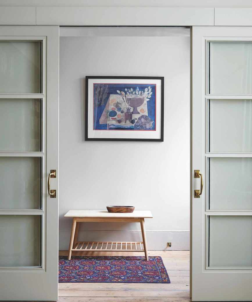 Minimal hallway with modern art and a colorful rug