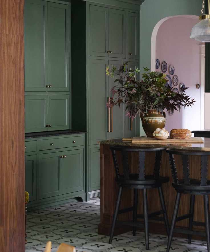A kitchen with dark green cabinets