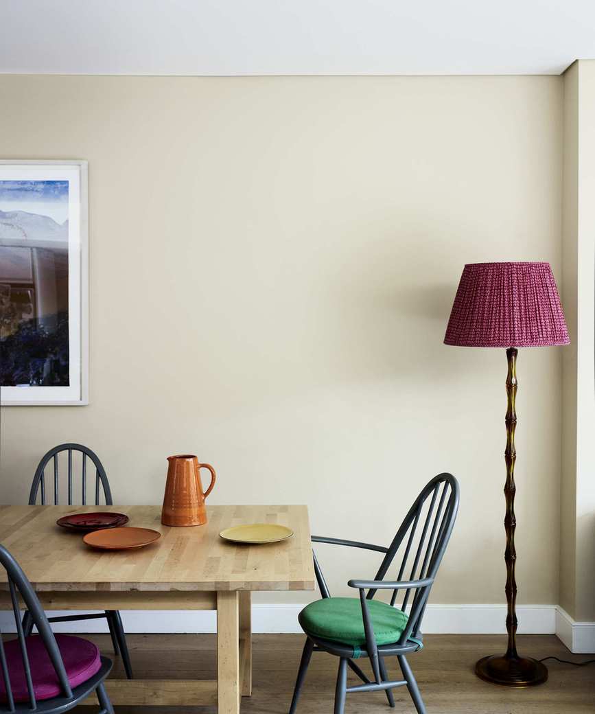 Dining room featuring a wooden table and chairs, with a pink lampshade floor lamp