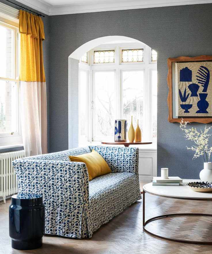 A cheerful living room featuring blue wallpaper and yellow highlights
