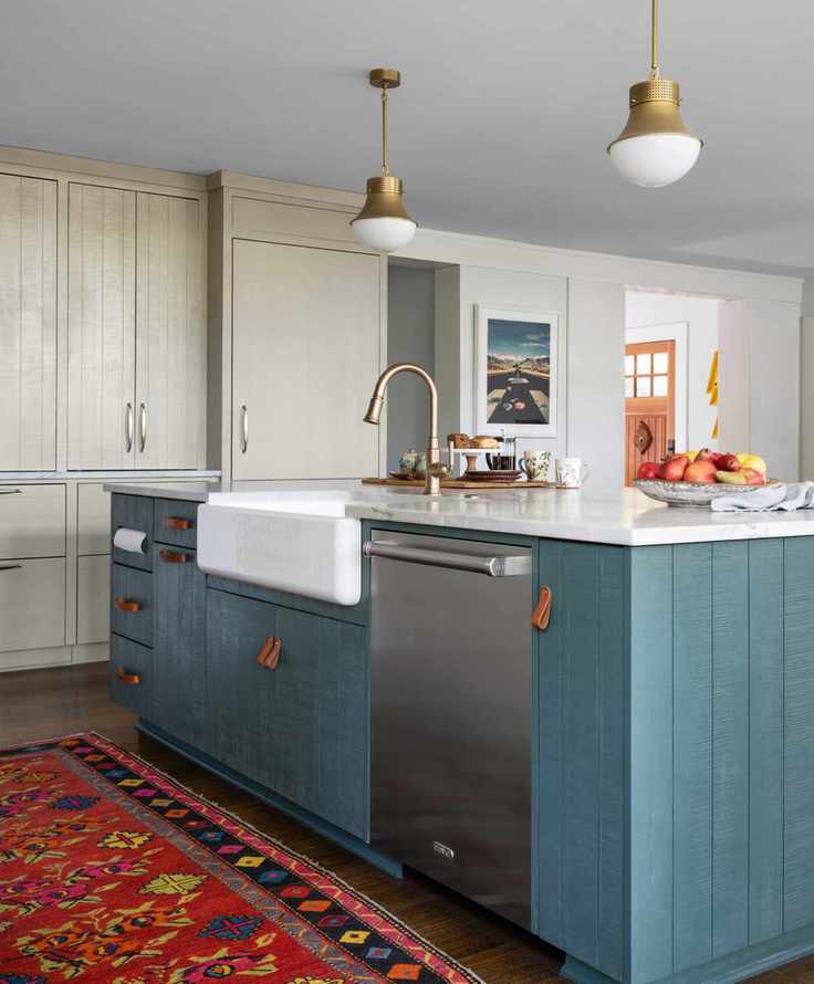 Kitchen with blue island featuring two types of leather cabinet hardware