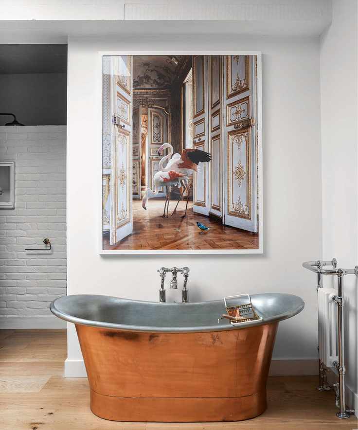 A white bathroom featuring art and stylish fixtures
