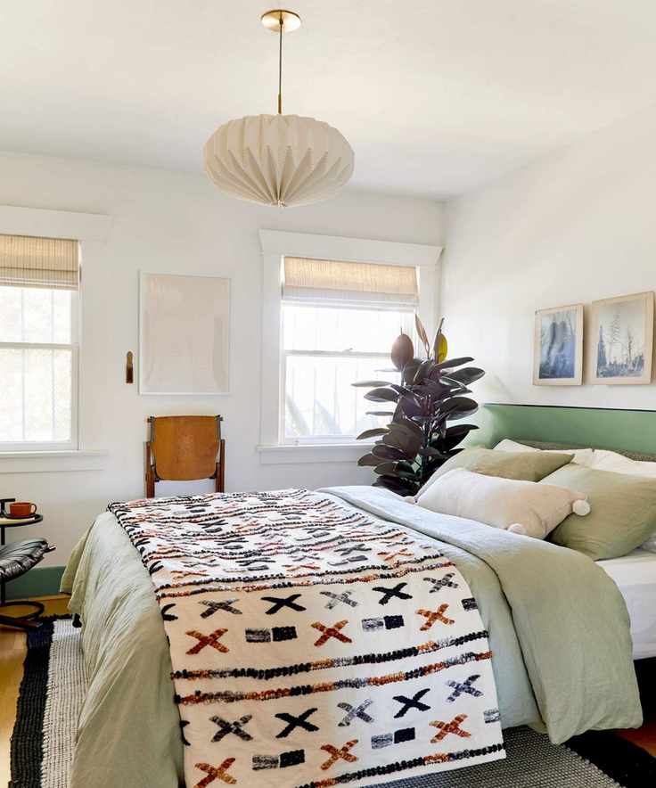 Small bedroom with neutral walls and patterned decor