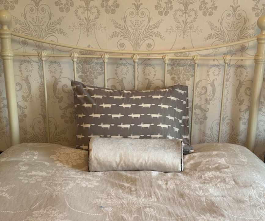 The Brooklinen Down Pillow in a pillowcase on a bed.