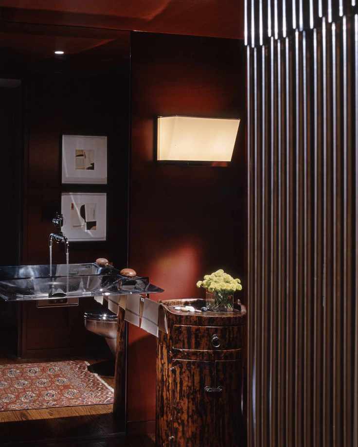red bathroom with red walls and ceiling, chrome basin, artwork, wall light, rug