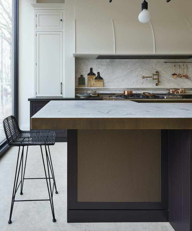 bronze island with marble top and black bar stool