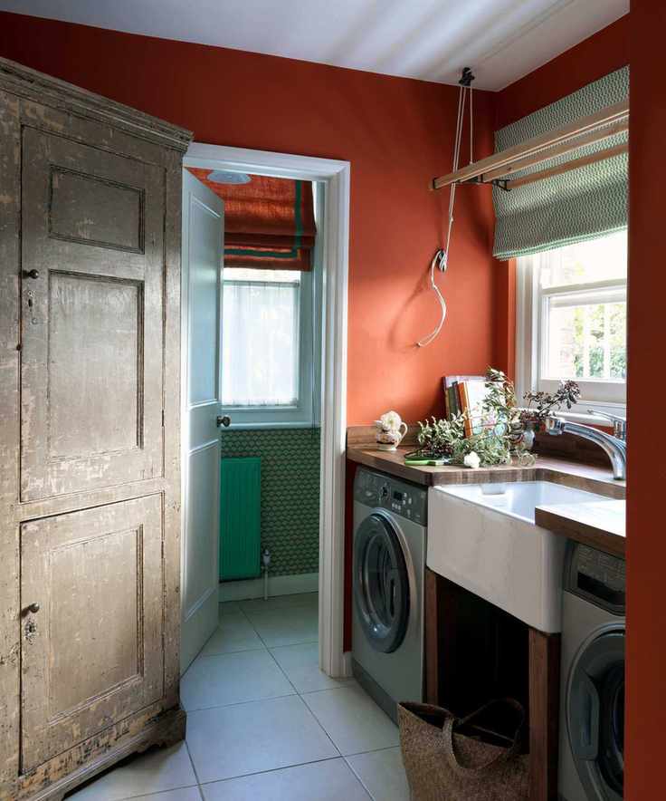A bright laundry room with wooden countertops and an antique cabinet.
