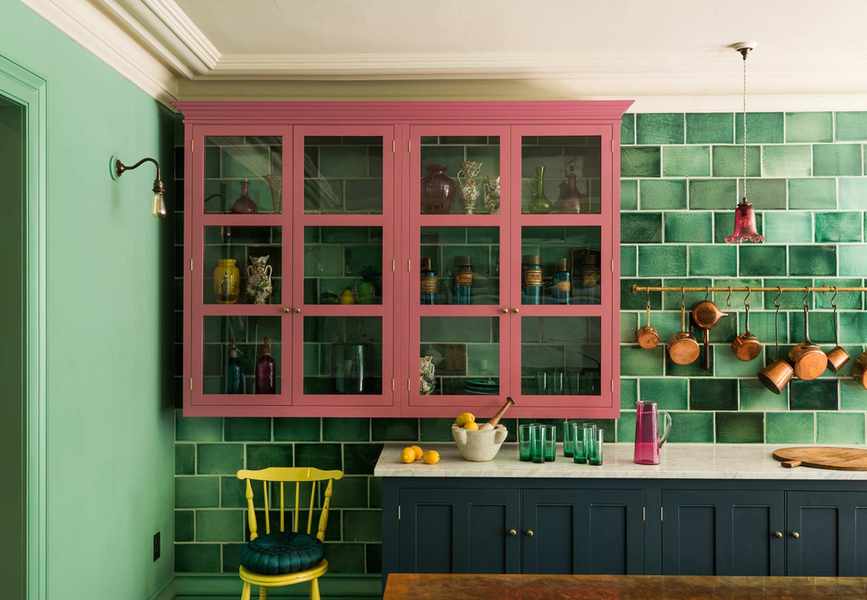 Kitchen with green tile wall, blue floor cabinets and pink wall cabinets