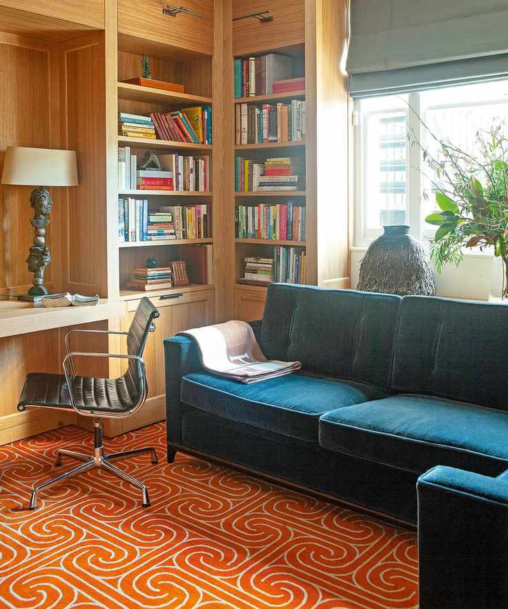 Orange patterned rug with blue sofa