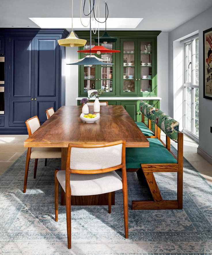 Dining room featuring mid-century furniture with colorful upholstery and painted cabinets