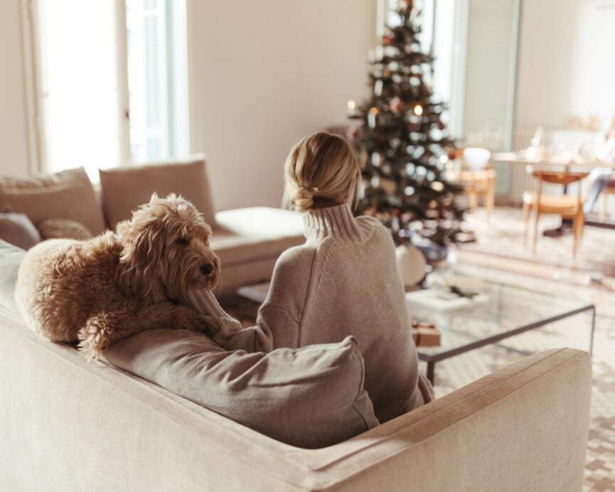 Woman with dog by Christmas tree