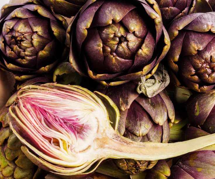A purple, ripe artichoke cut in half