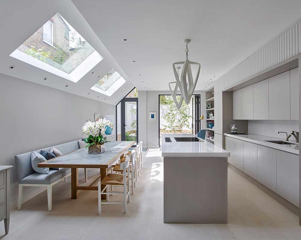 A bright kitchen with a narrow island and large dining table