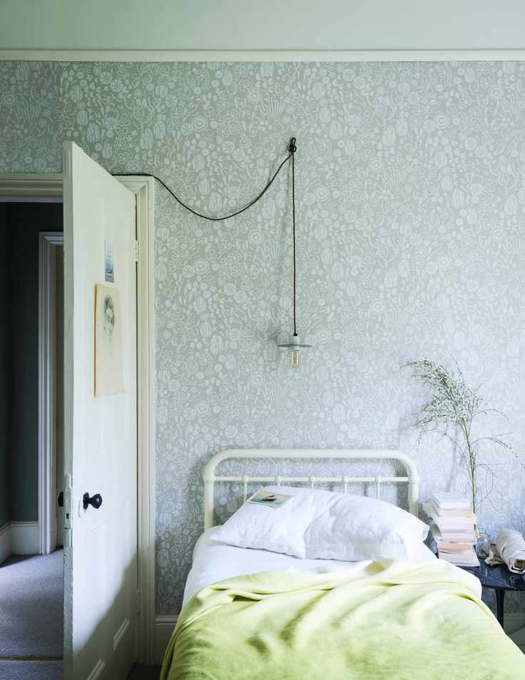 gray and lemon yellow bedroom with gray single color wallpaper, lemon yellow blanket, white iron single bed, bulb pendant light, black side table