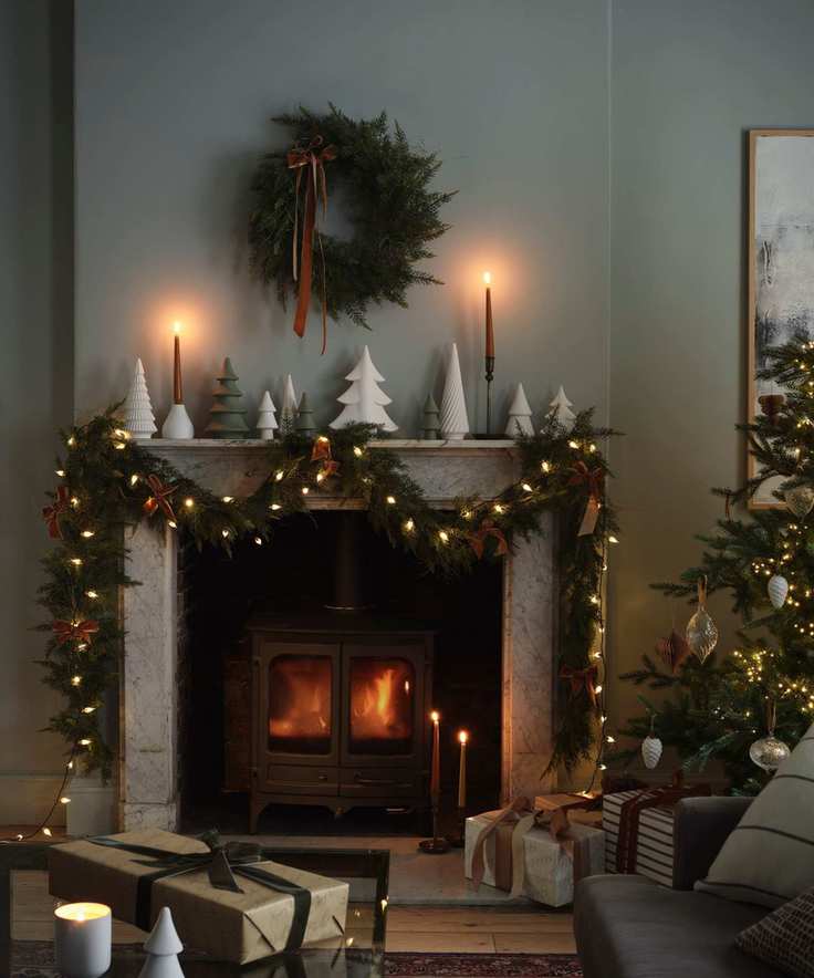 cozy living room with mantelpiece with Christmas garland, Christmas wreath and candles with log burner