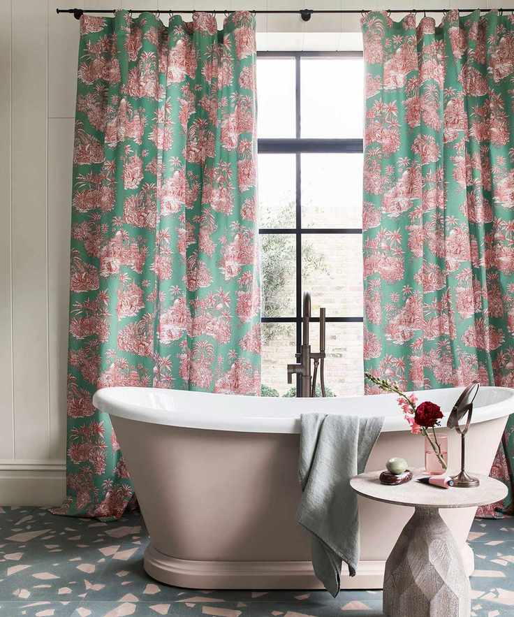 freestanding pink painted bath with toile curtains and terrazzo floor tiles