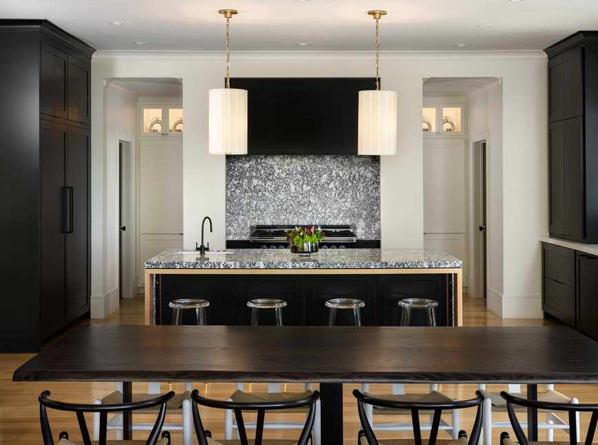 Kitchen with dining table and chairs, island and stove with backsplash