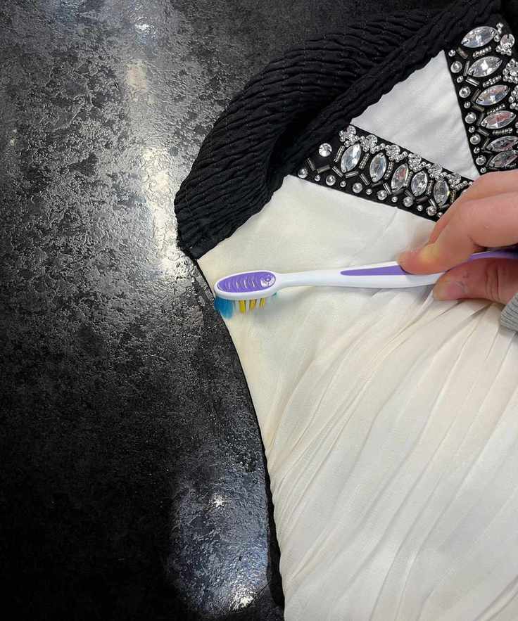 Scrubbing at a yellow stain with a purple toothbrush