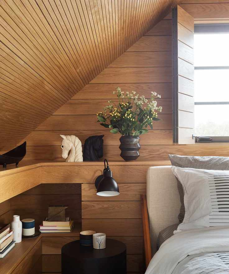 Small bedroom storage solutions in a wooden room with a sloped ceiling.