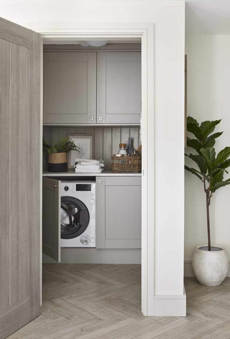 A laundry room with a washing machine and built in cabinetry