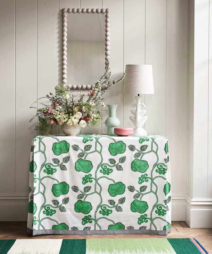 A console table with a table lamp and decorative items