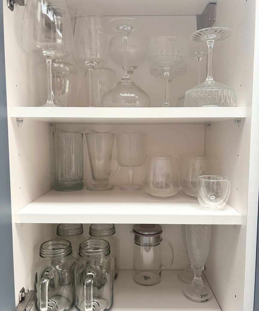 A kitchen cupboard with organized glassware