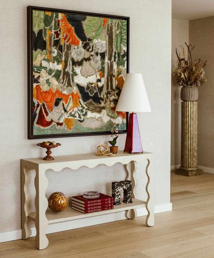 White curved wooden table, painting, lamp