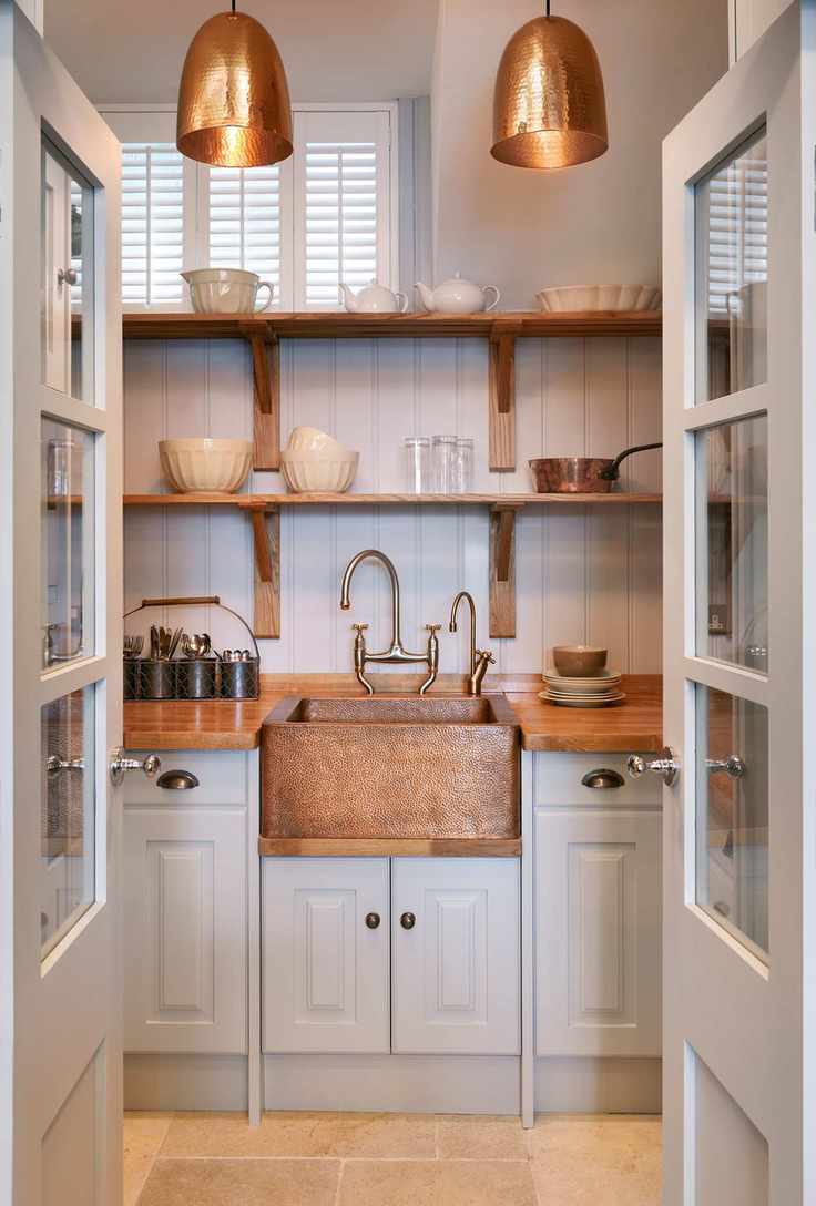 white kitchen with copper sink, taps and pendant lights