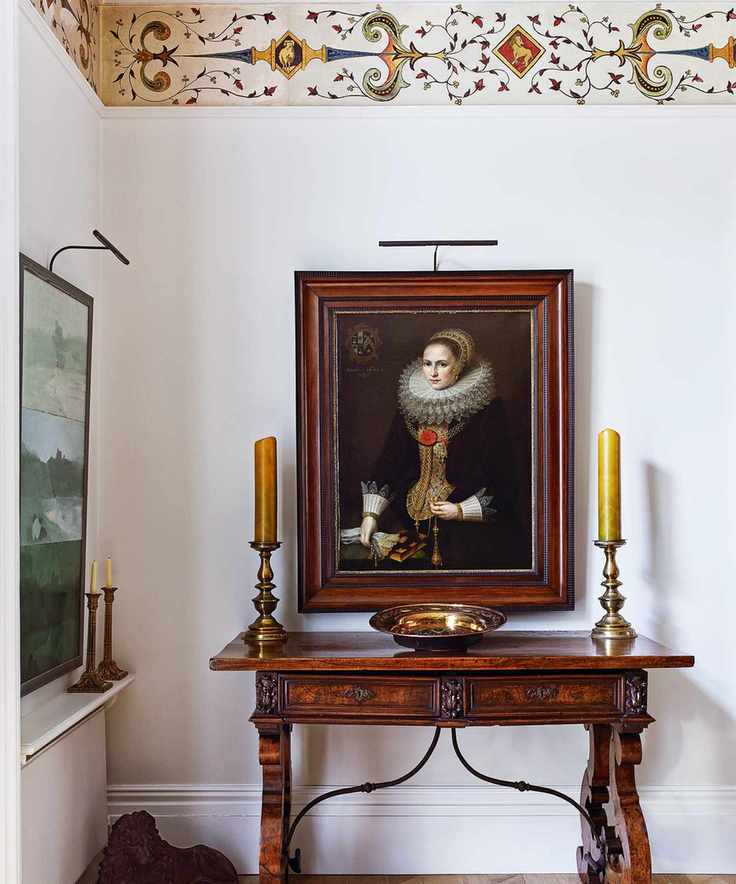 A hallway with a spotlight illuminating a painting