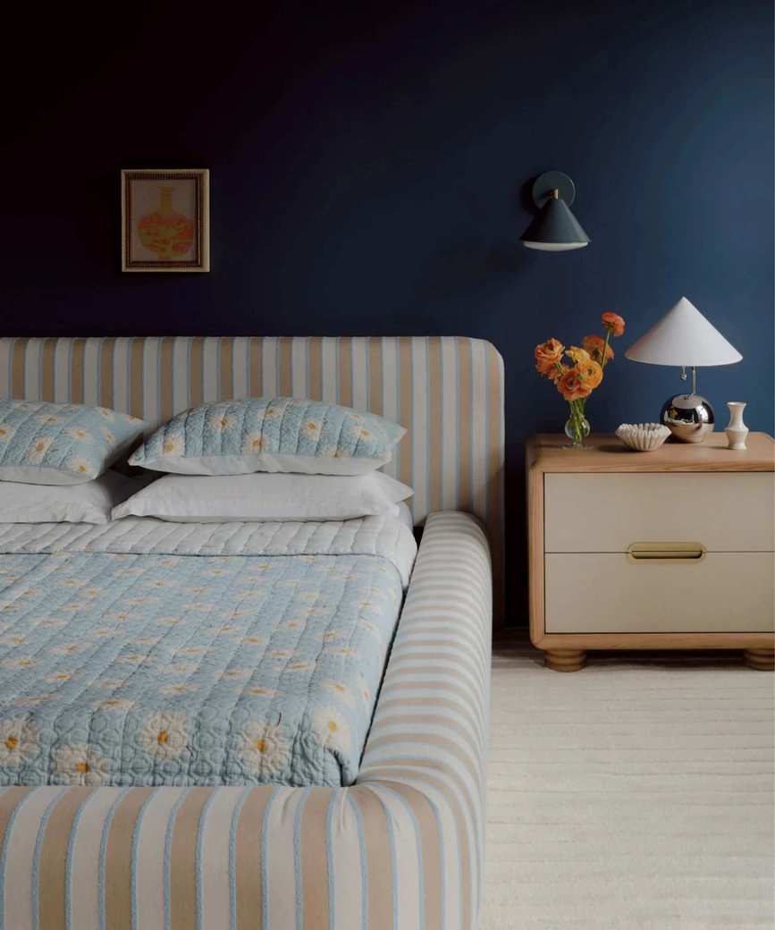 bedroom from the anthropologie artful aesthete bedroom with a beige and blue striped upholstered bed and chrome decor