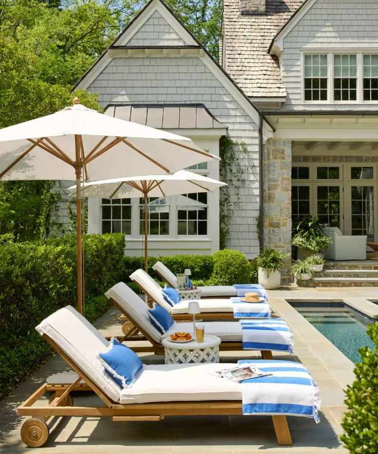 Poolside shot with sun loungers and blue and white striped towels and cushions