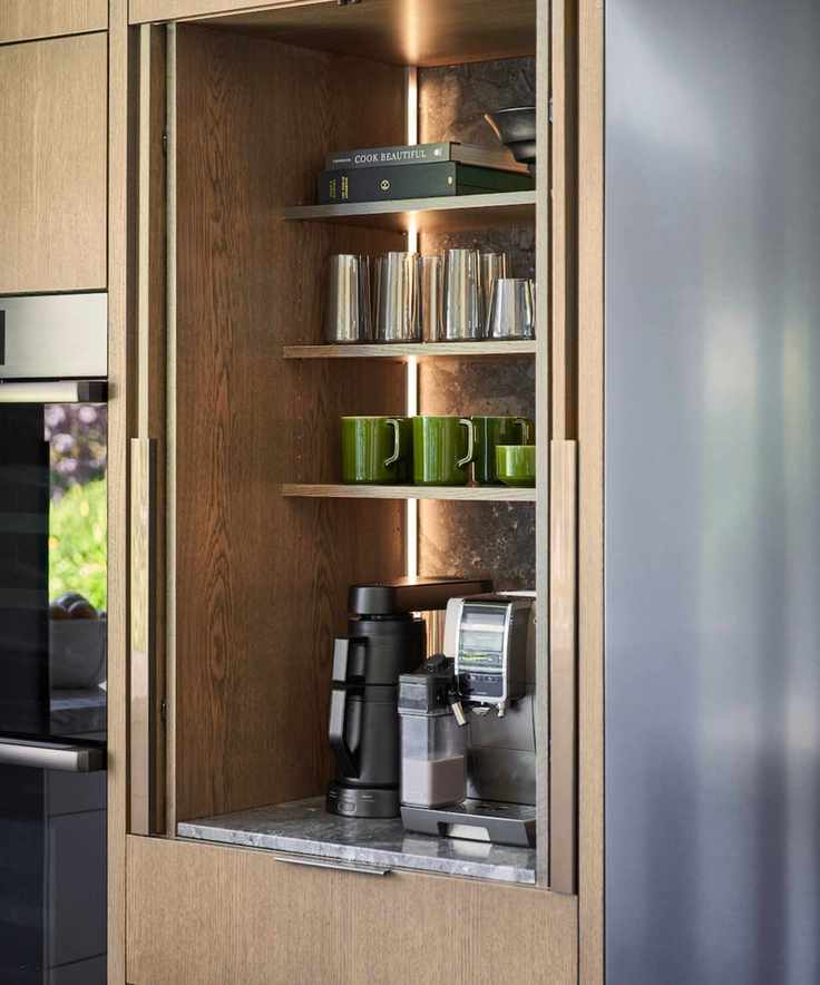 An at-home coffee station with coffee makers, green mugs and glasses.