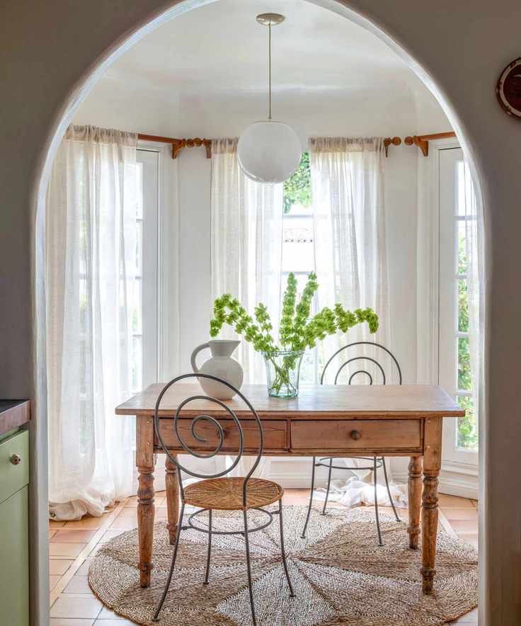 breakfast or coffee table nook with a small archway and french doors and a bistro table and iron chairs