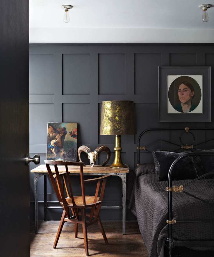 Bedroom featuring black paneling and furnishings, creating a cozy atmosphere