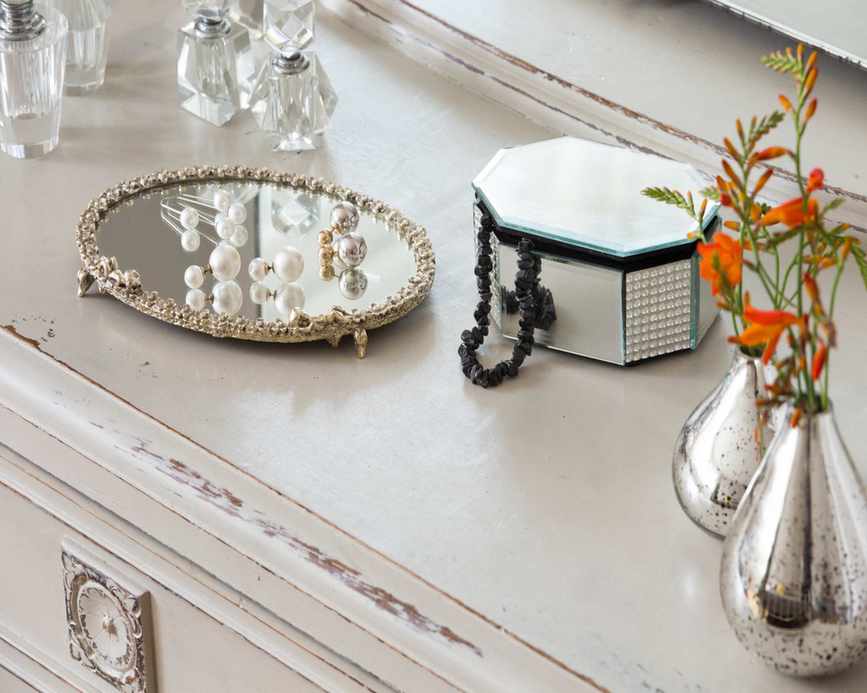 Chest of drawers with jewelry and vases on surface